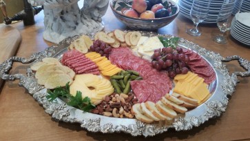 Cheese and charcuterie board made with imported and domestic cheeses, cured meats, fruit, nuts and cornichones.